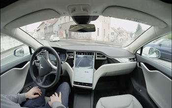 man sitting in self driving car with big screen radio